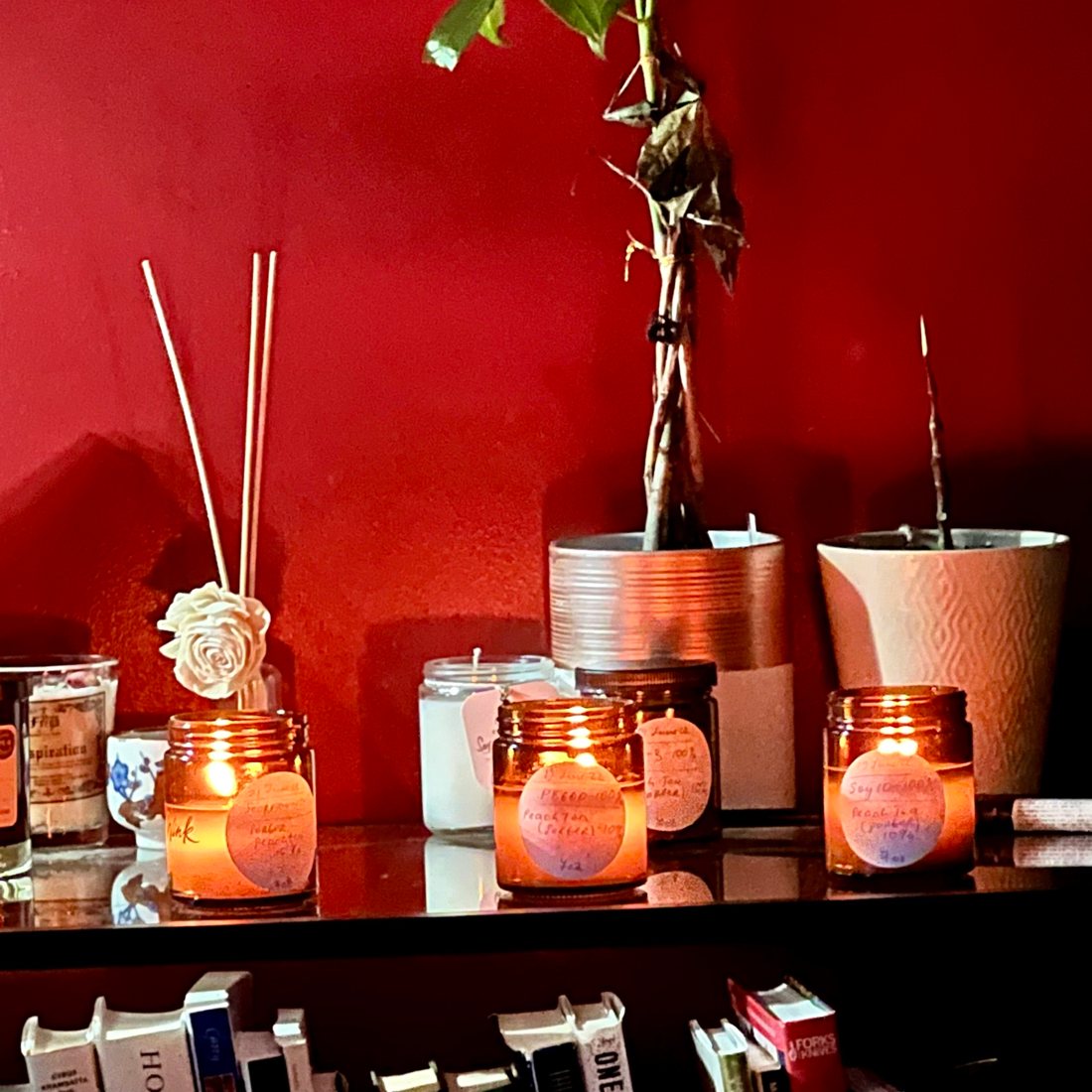 Hand-labelled candle testers burning on a shelf.