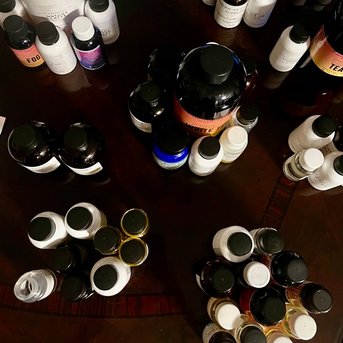 A table covered with fragrance oil bottles, seen from above.